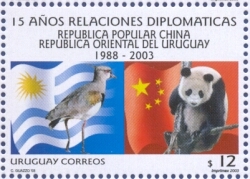 Dibujo de bandera uruguaya con tero al frente junto a dibujo de bandera china con oso panda. En la parte superior cita lo siguiente: 15 Años Relaciones Diplomáticas República Popular China. República Oriental del Uruguay. 1988-2003. En la parte inferior cita: Uruguay Correos.