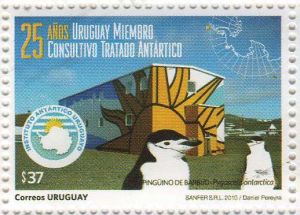 Fotografía de Base Científica Artigas, acompañada de logo de Instituto Antártico del Uruguay, con pingüinos de barbijo.