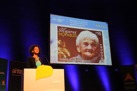 Presidenta del Correo Uruguayo, Solange Moreira, junto a la imagen del sello Mujeres Notables - Luisa Cuesta