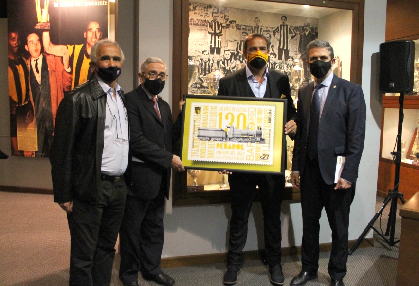 Autoridades de ambas instituciones junto a la gigantografía del sello