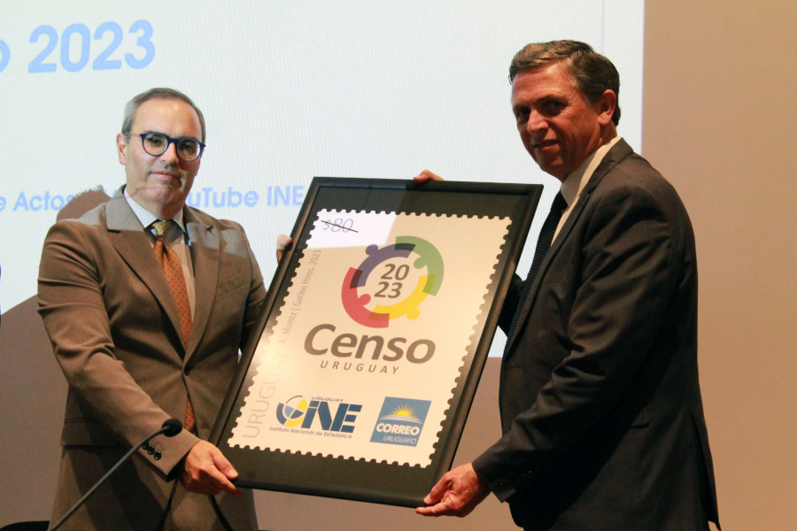 Presidente de Correo Uruguayo y Director Técnico del INE exhiben la reproducción del sello conmemorativo