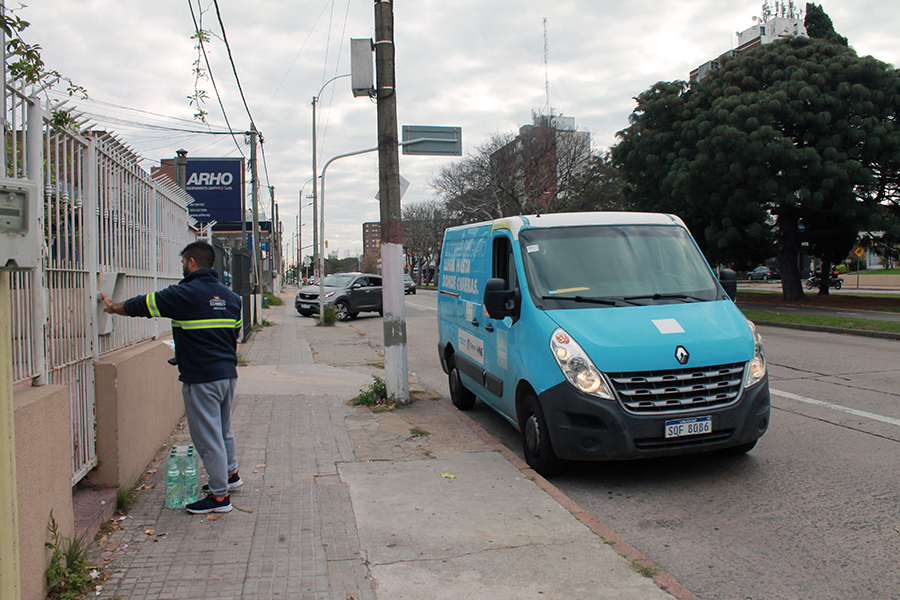 Funcionario de Correo Uruguayo toca timbre en un domicilio para realizar la entrega