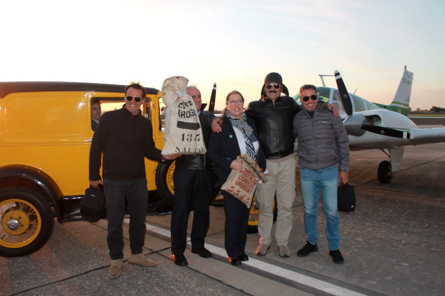 Tripulantes del vuelo y Director de Correo Uruguayo posan junto al avión y la cachila