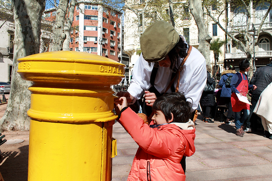 Niño coloca un sobre en el buzón
