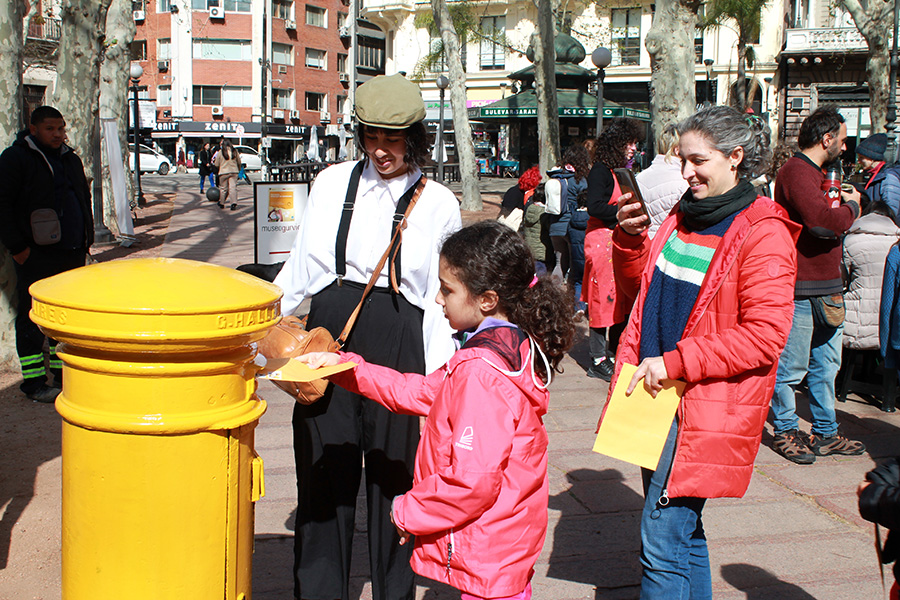 Niña coloca un sobre en el antiguo buzón