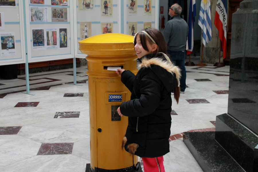 Niña deposita su carta en el buzón