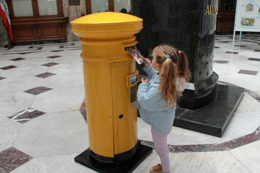 Niña deposita su carta en el buzón