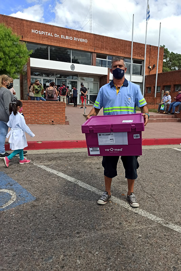 Funcionario de Correo Uruguayo transportando las cajas térmicas