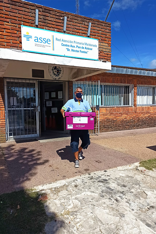 Funcionario de Correo Uruguayo transportando las cajas térmicas